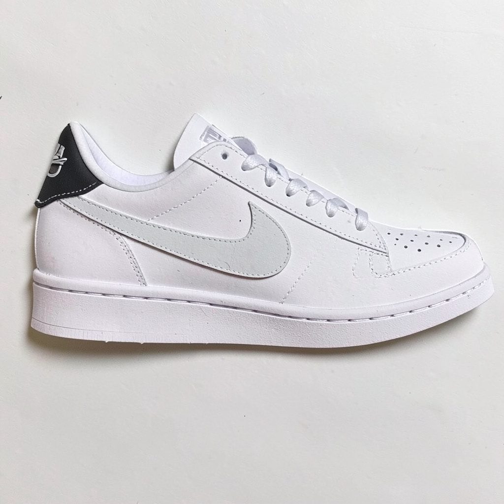 Layered paper cutout of a classic tennis style sneaker in cream and muted gray