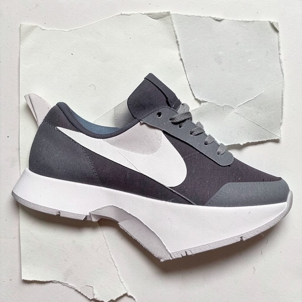 Layered paper cutout of dark navy running shoes with subtle highlights